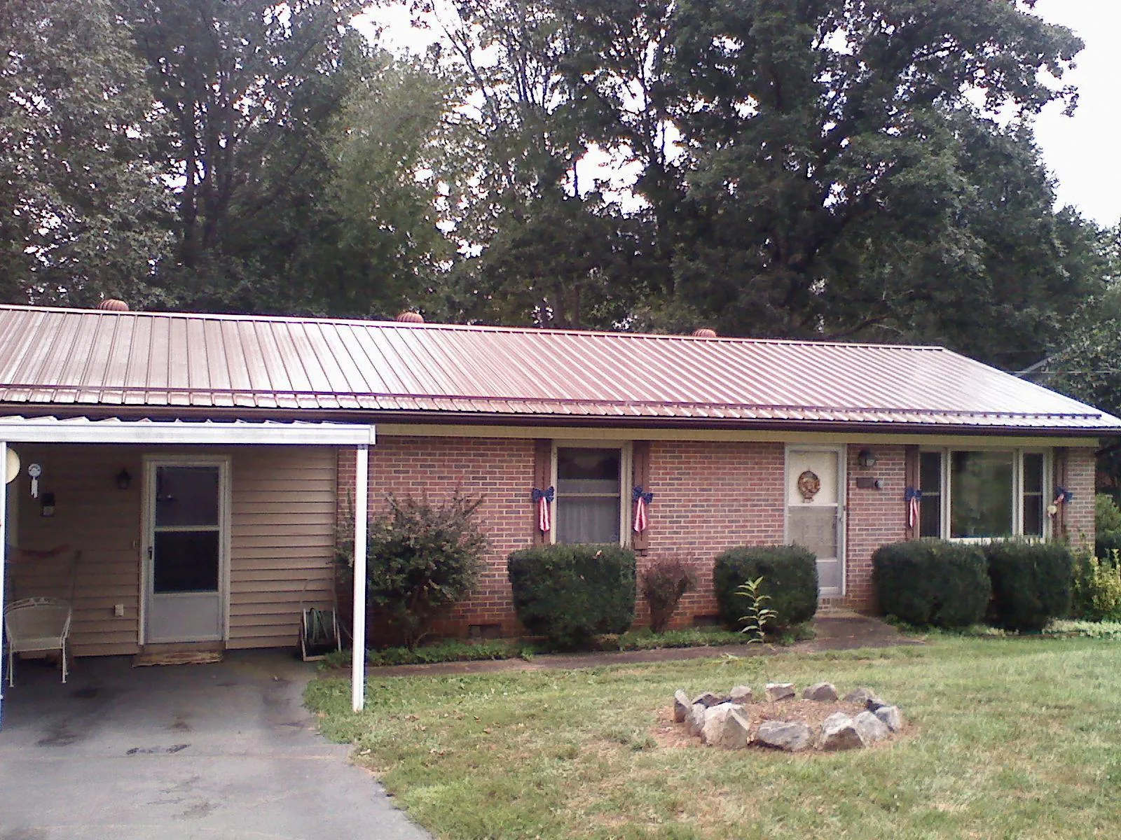 Bronze metal roof and carport on a brick ranch home — Roof Repair work by our crew in Anna